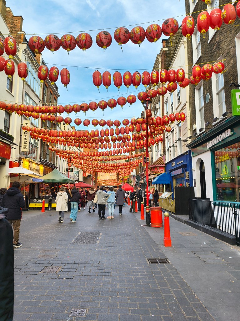 Family visiting Chinatown in London for eating and shopping where Chinese lanterns are decorated.